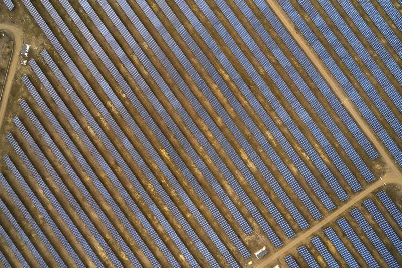 Solar panels in a large cluster forming solar power plant, top down aerial view