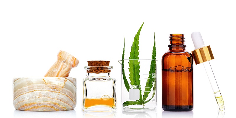 Glass bottles of cannabis oil and hemp leaves isolated on white background. Concept of using hemp in medicine.