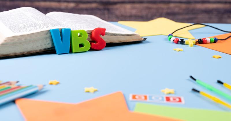 Church background with Abbreviation "VBS" (Vacation Bible School) next to black bible . Copy space text. Selective focus.